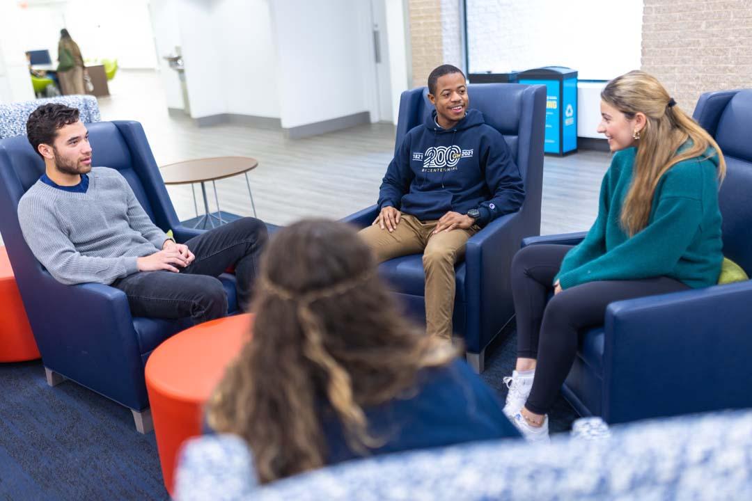 Four students talking in a circle